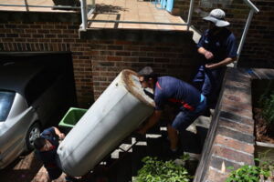 Technicians disposing of a old rusty water heater